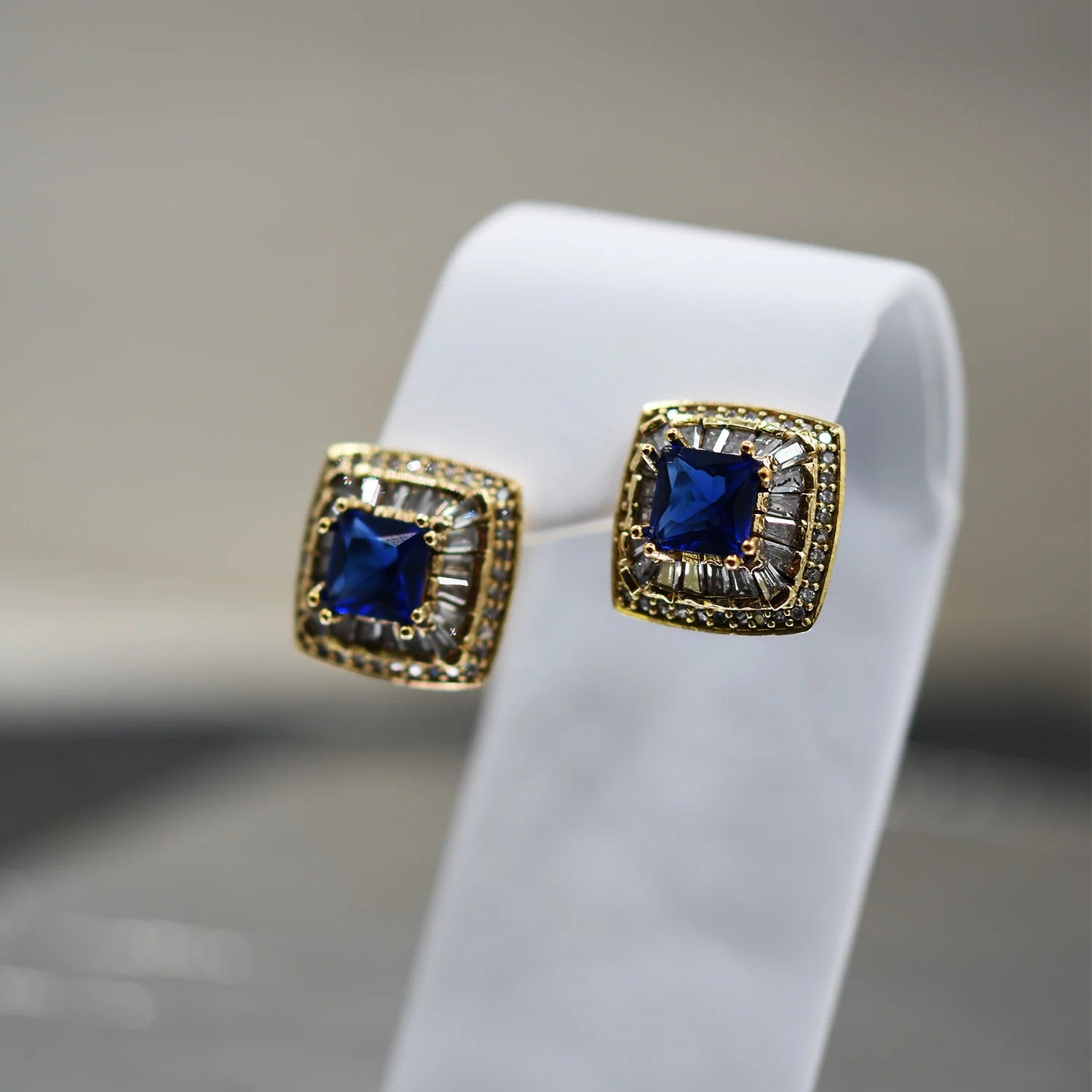 Cubic Zirconia clustered stud square earrings with blue stone center